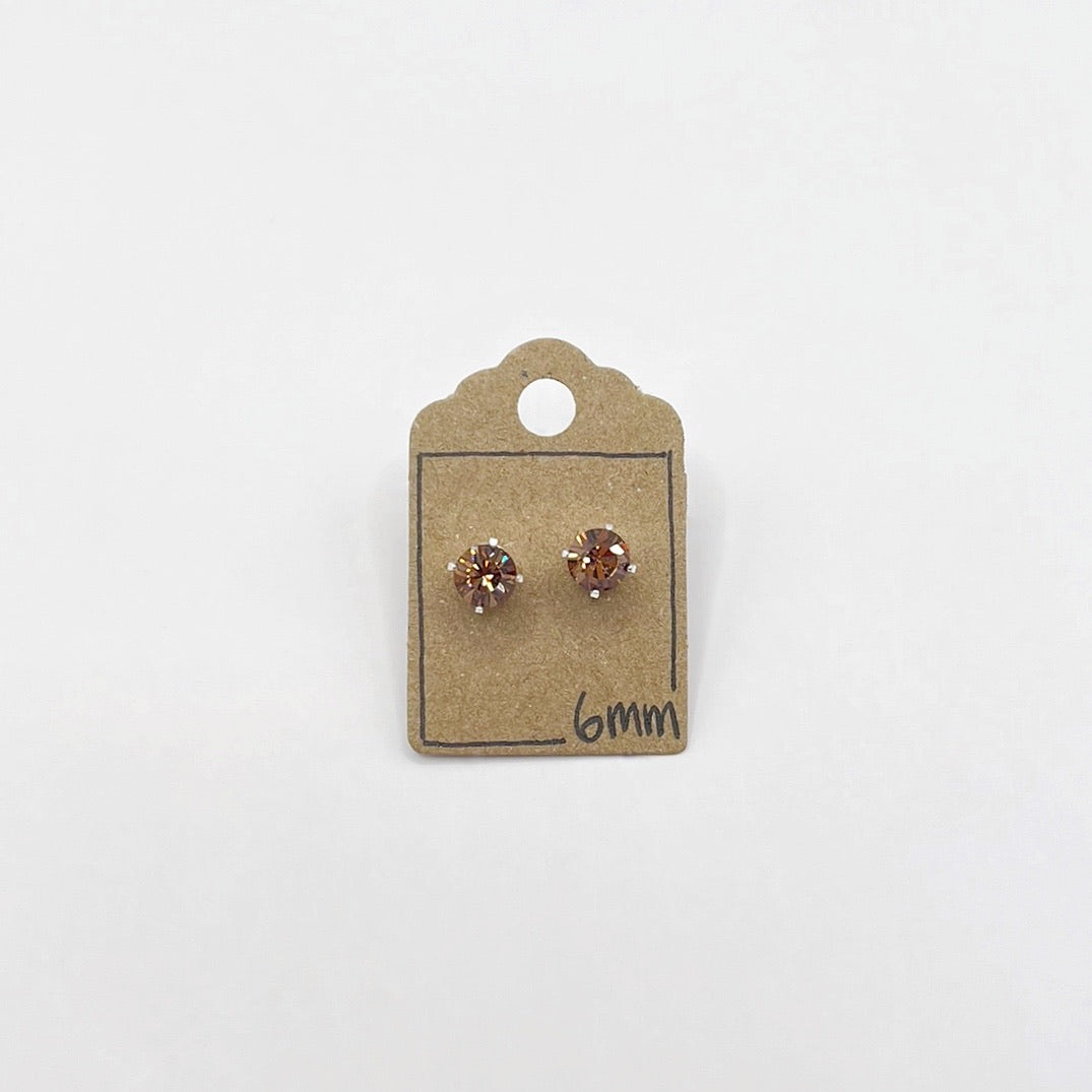 Pair of small cut glass stud earrings on a cardboard backing with '6mm' marking on a white background