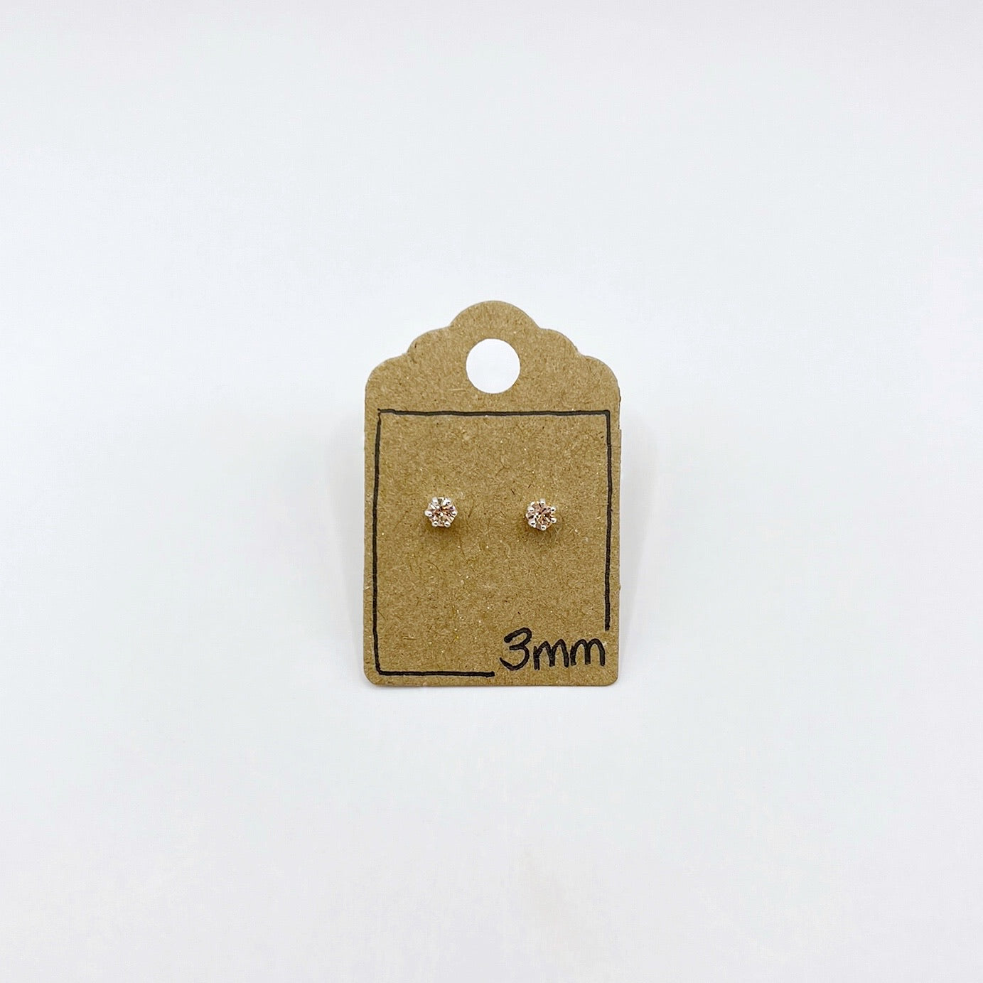 Pair of silver stud earrings on a small cardboard card with '3mm' text, against a white background