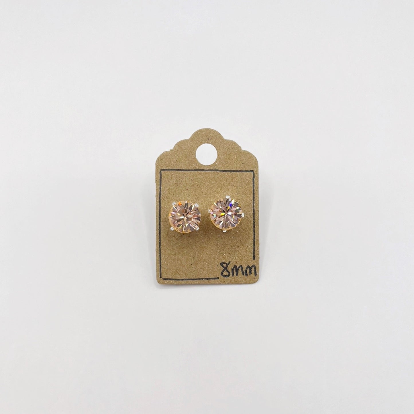 Pair of cut glass stud earrings on a cardboard backing with '8mm' marking against a white background