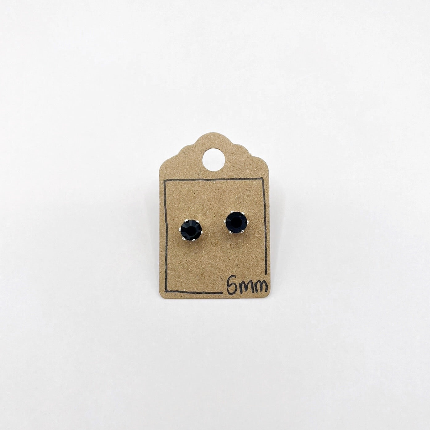 Pair of black stud earrings on a brown cardboard backing with '5mm' text on a white background