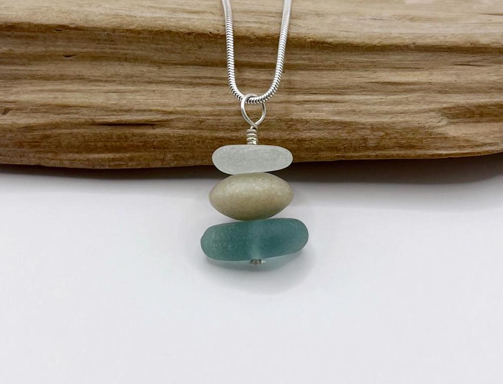 Necklace with stacked sea glass and Jade leant against driftwood