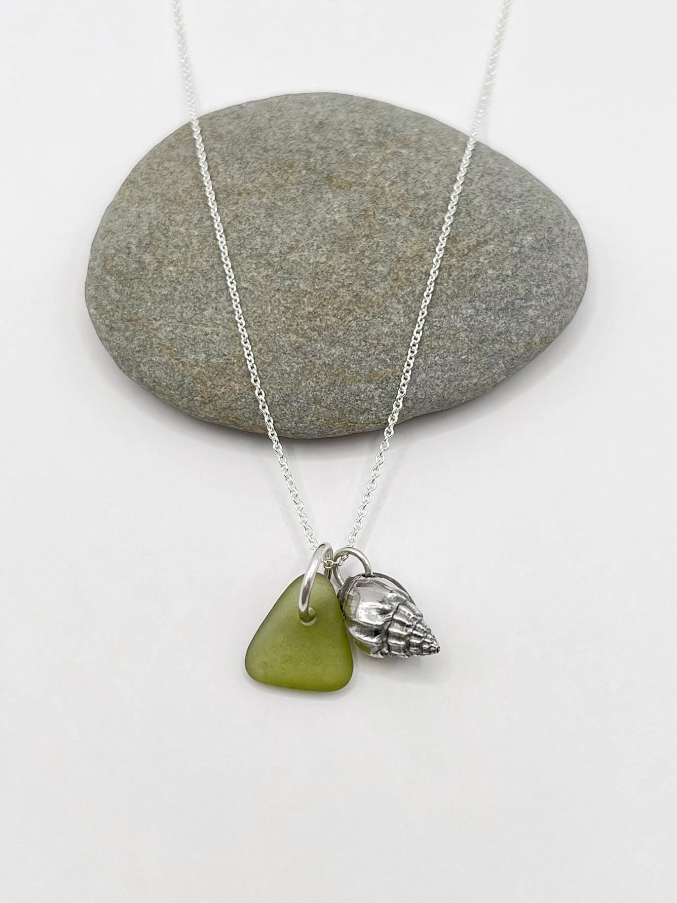 Necklace with green sea glass and silver shell pendant on a white background