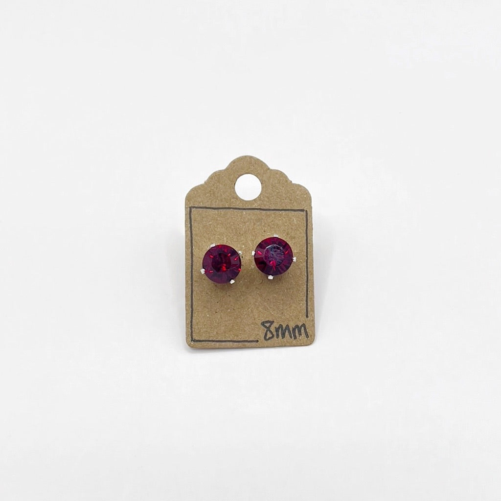 Pair of red cut glass stud earrings on a cardboard backing with '8mm' marking.