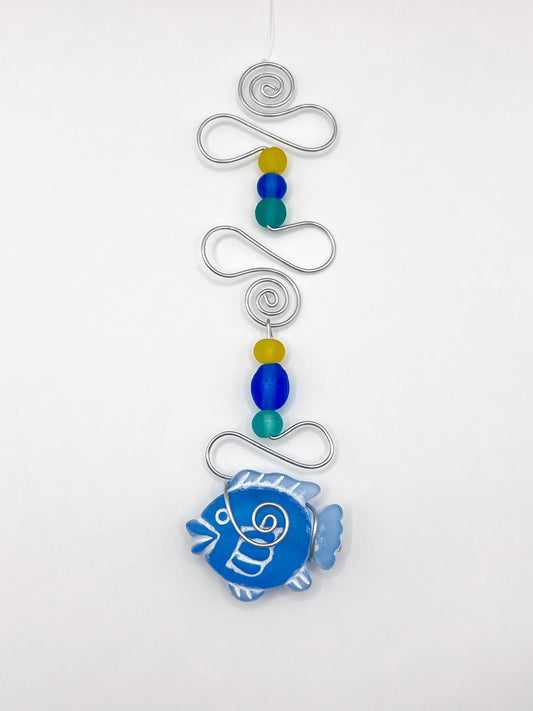 Decorative ornament with blue fish design, wire and colourful beads on a white background