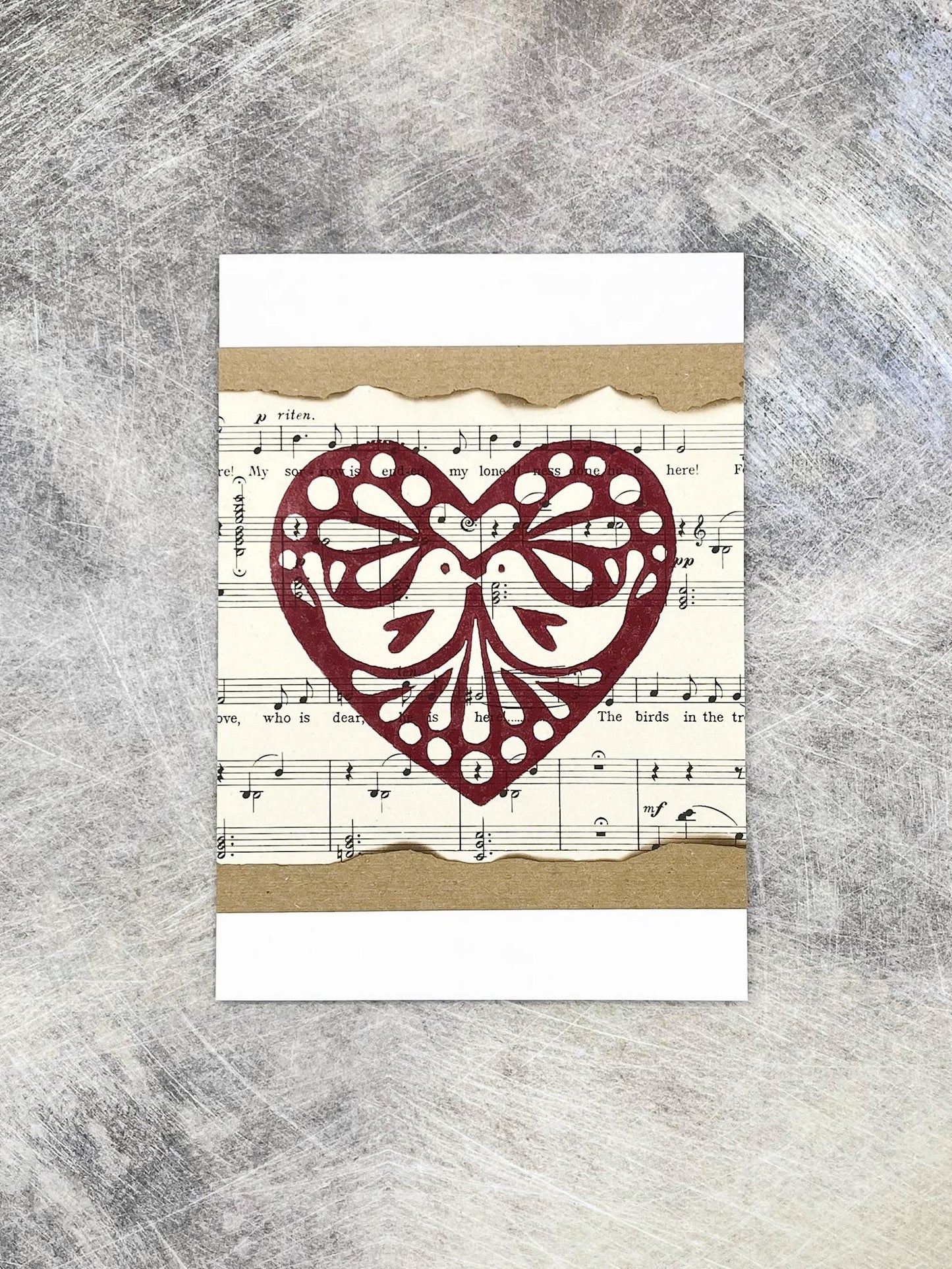 Card with original lino printed heart design on sheet music background
