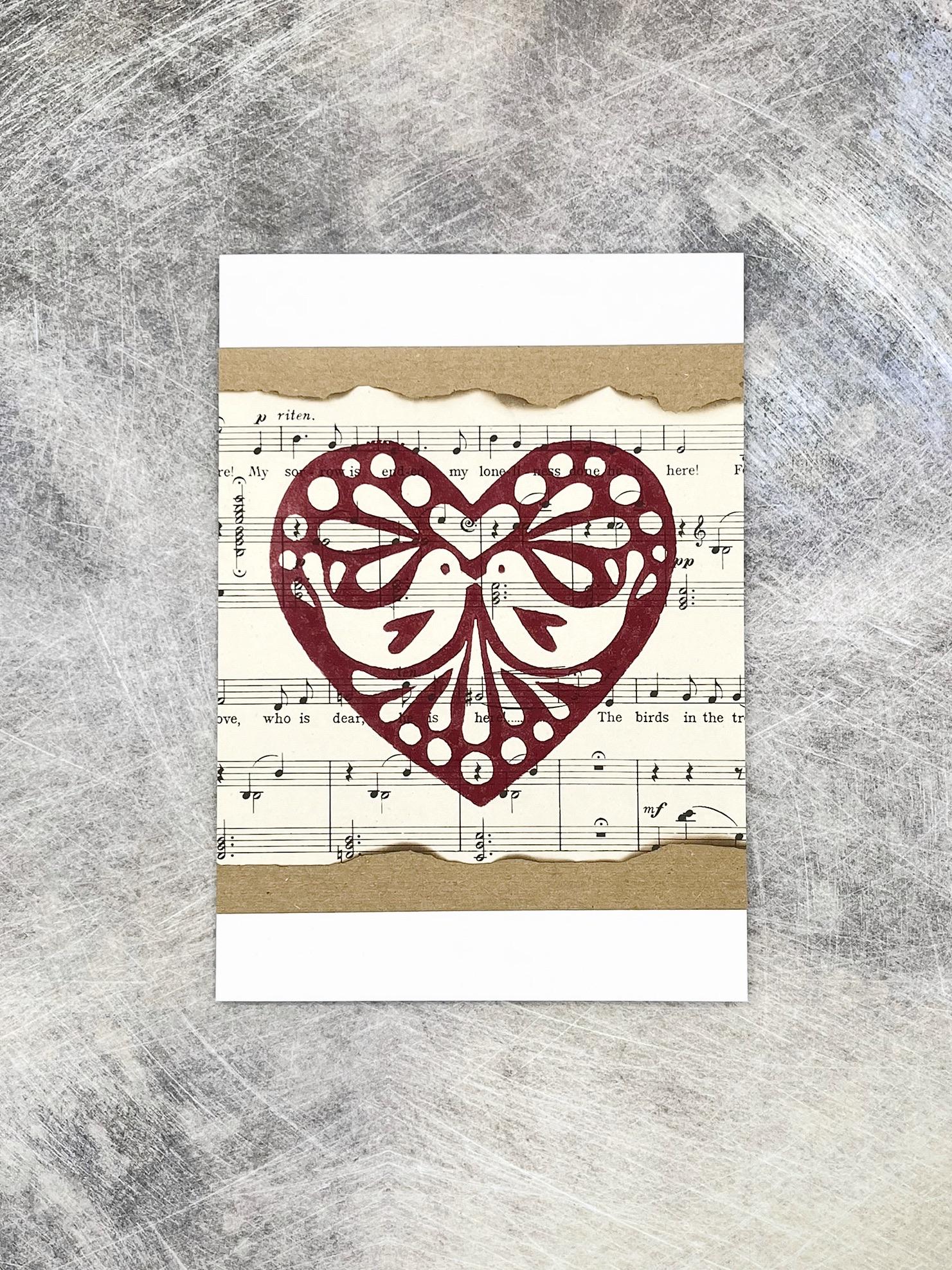 Card with original lino printed heart design on sheet music background