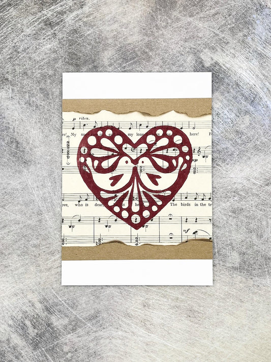 Card with original lino printed heart design on sheet music background