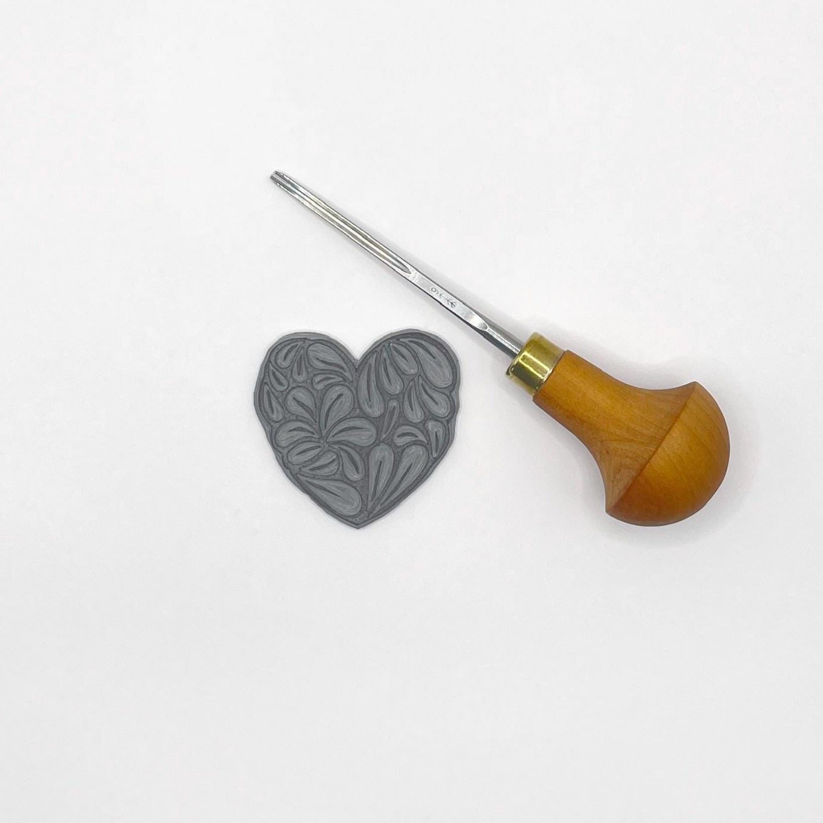 Lino and cutting tool used for the A6 sketchbook on a white background