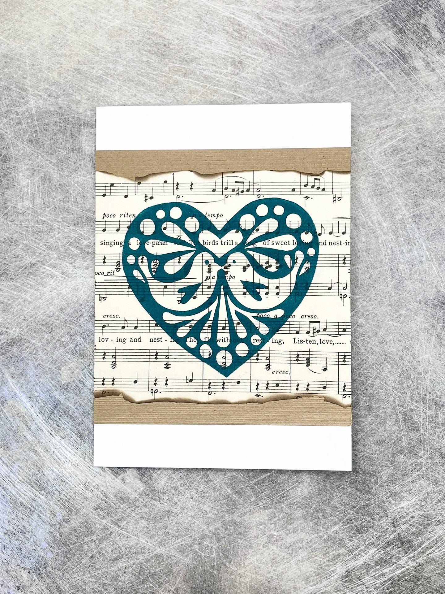 Card with decorative green heart design on sheet music background