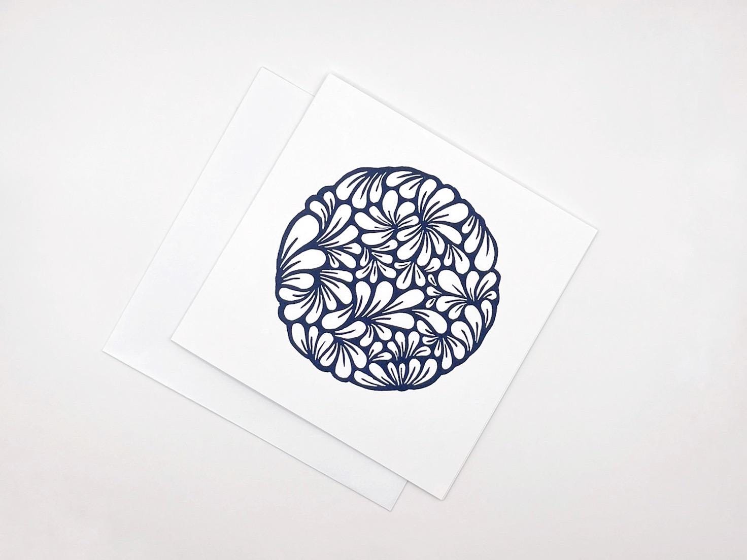 Original navy blue lino printed mussel shell pattern on white card laid on a white background.