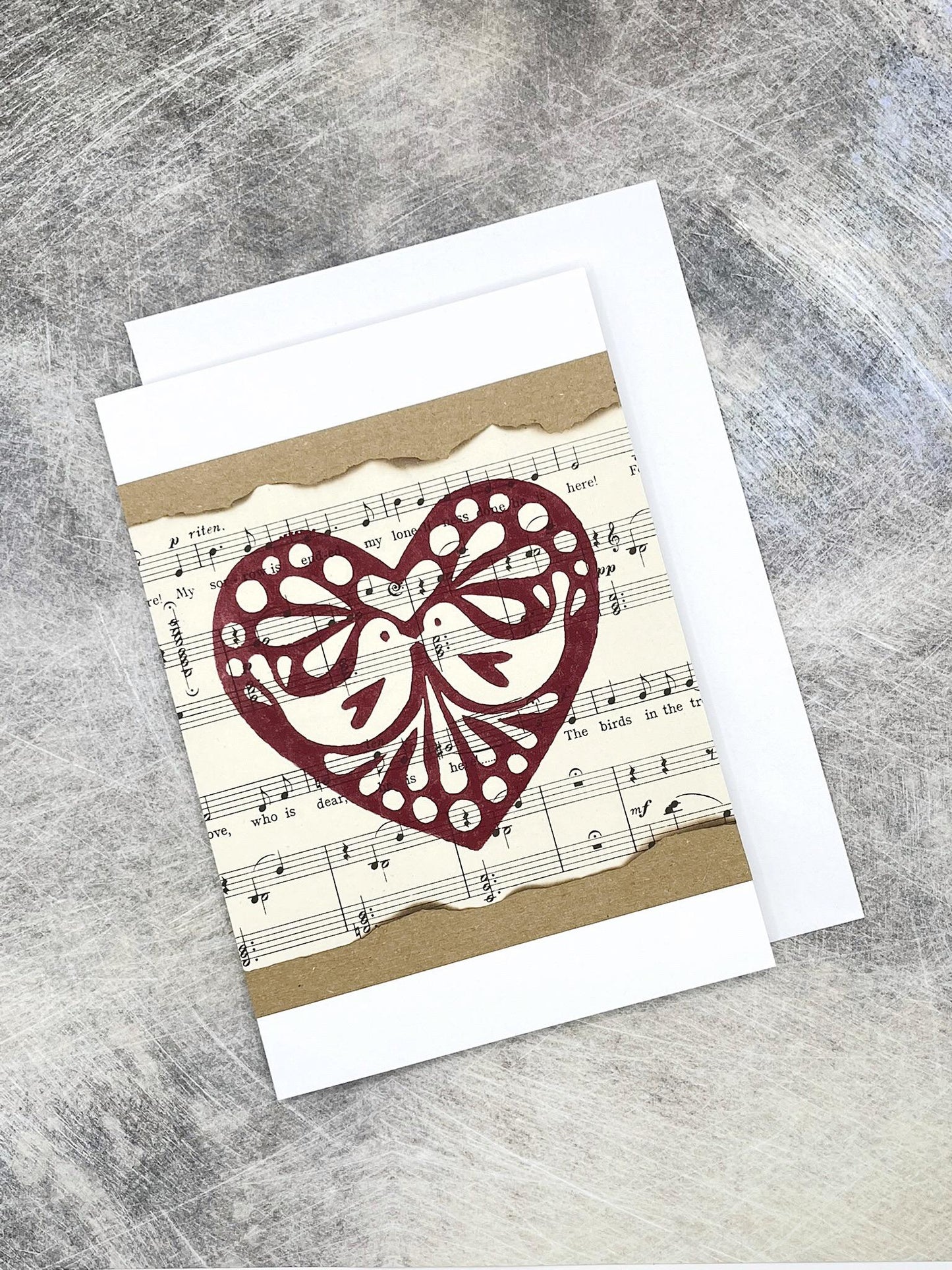 Greeting card with original lino printed heart design on sheet music 