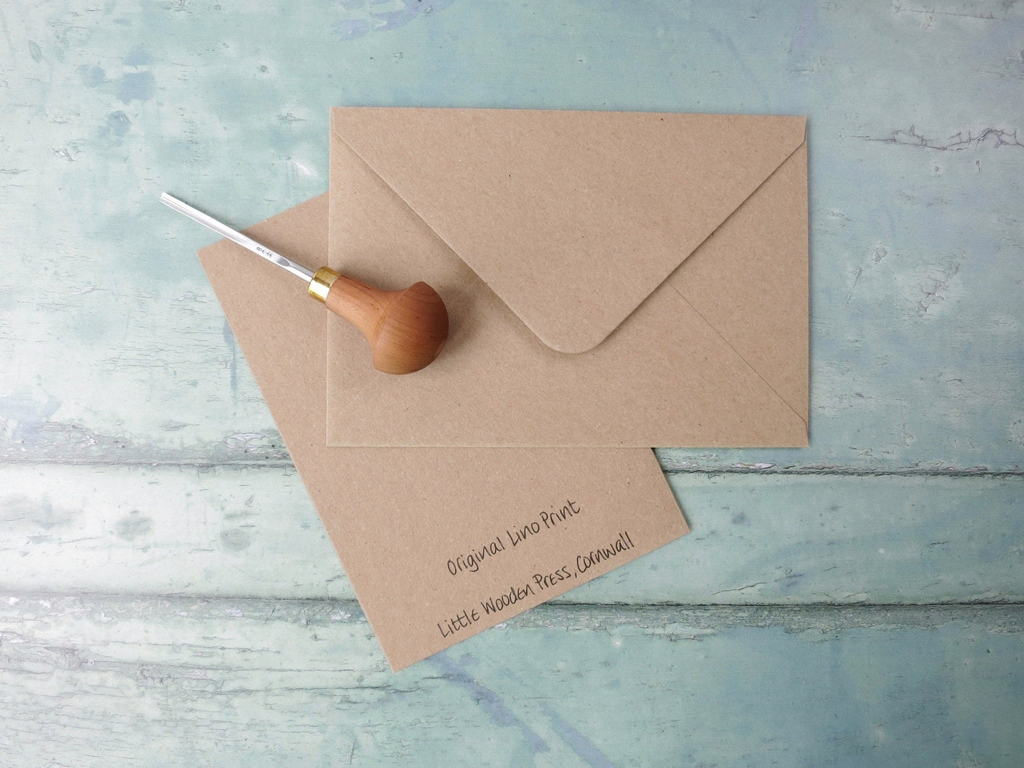 Kraft paper envelope and card on a textured blue surface