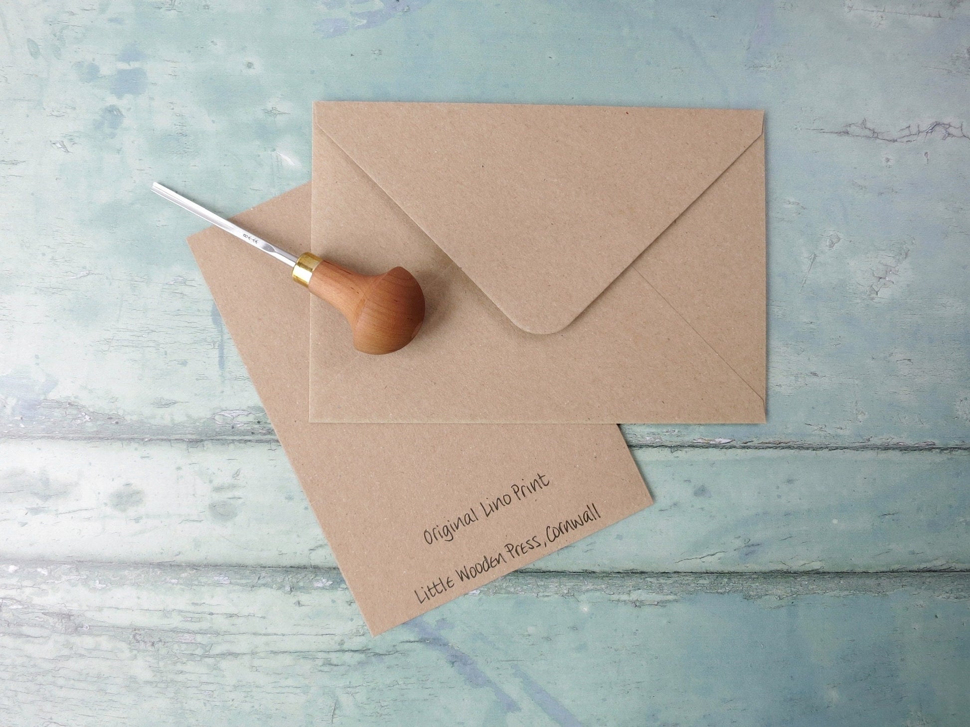 Kraft paper envelope and card on a textured blue surface