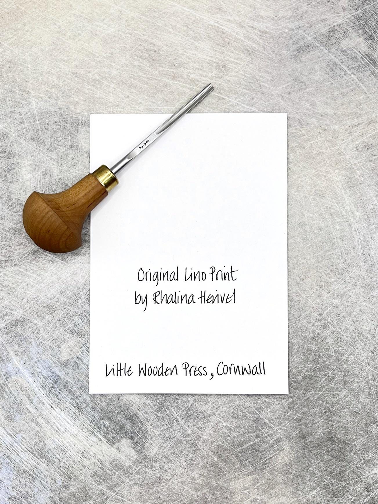 The back of the card showing the text, Original lino print by Rhalina Herivel. Little Wooden Press, Cornwall. Included in the photo is the lino cutting tool used.