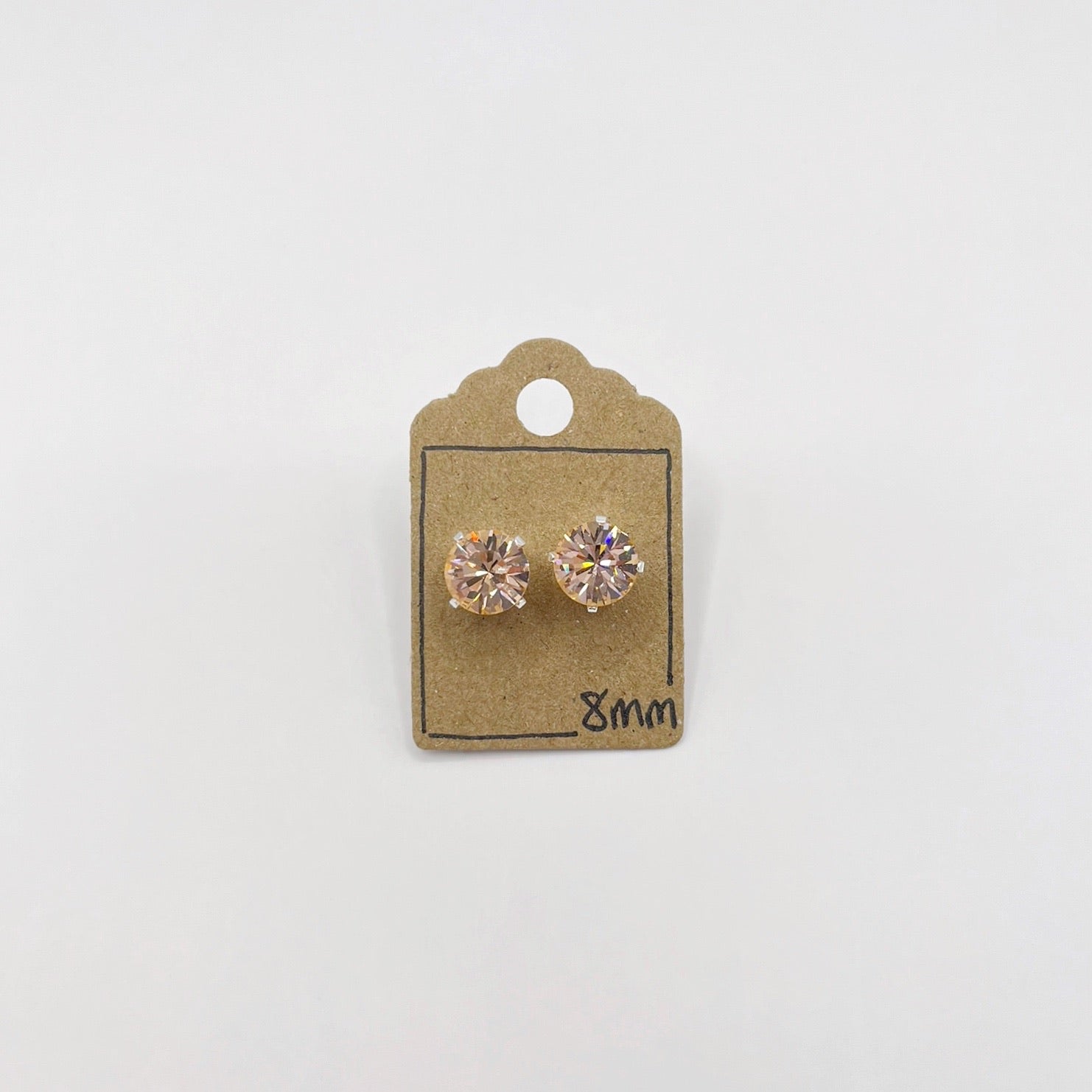 Pair of cut glass stud earrings on a cardboard backing with '8mm' marking against a white background