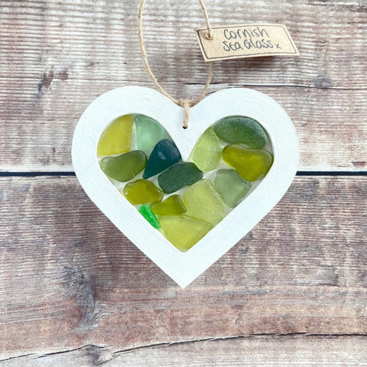 Heart-shaped sea glass hanging decoration with a 'Cornish Sea Glass' tag on a wooden surface