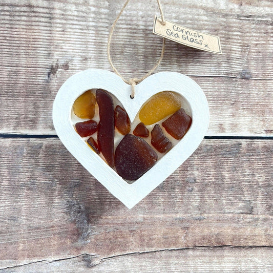 Heart-shaped sea glass hanging decoration with a 'Cornish Sea Glass' tag on a wooden surface