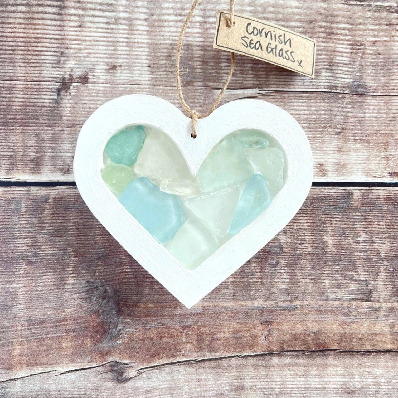Heart-shaped sea glass hanging decoration with a 'Cornish Sea Glass' tag on a wooden surface
