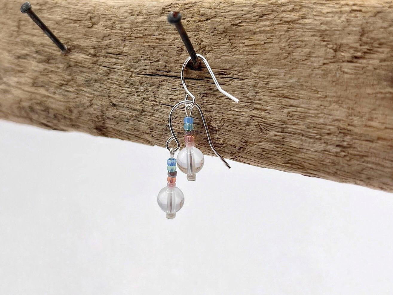 Pair of beaded earrings on driftwood