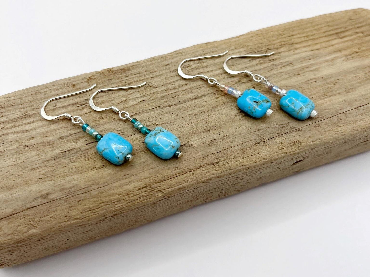 Turquoise bead earrings on a wooden surface
