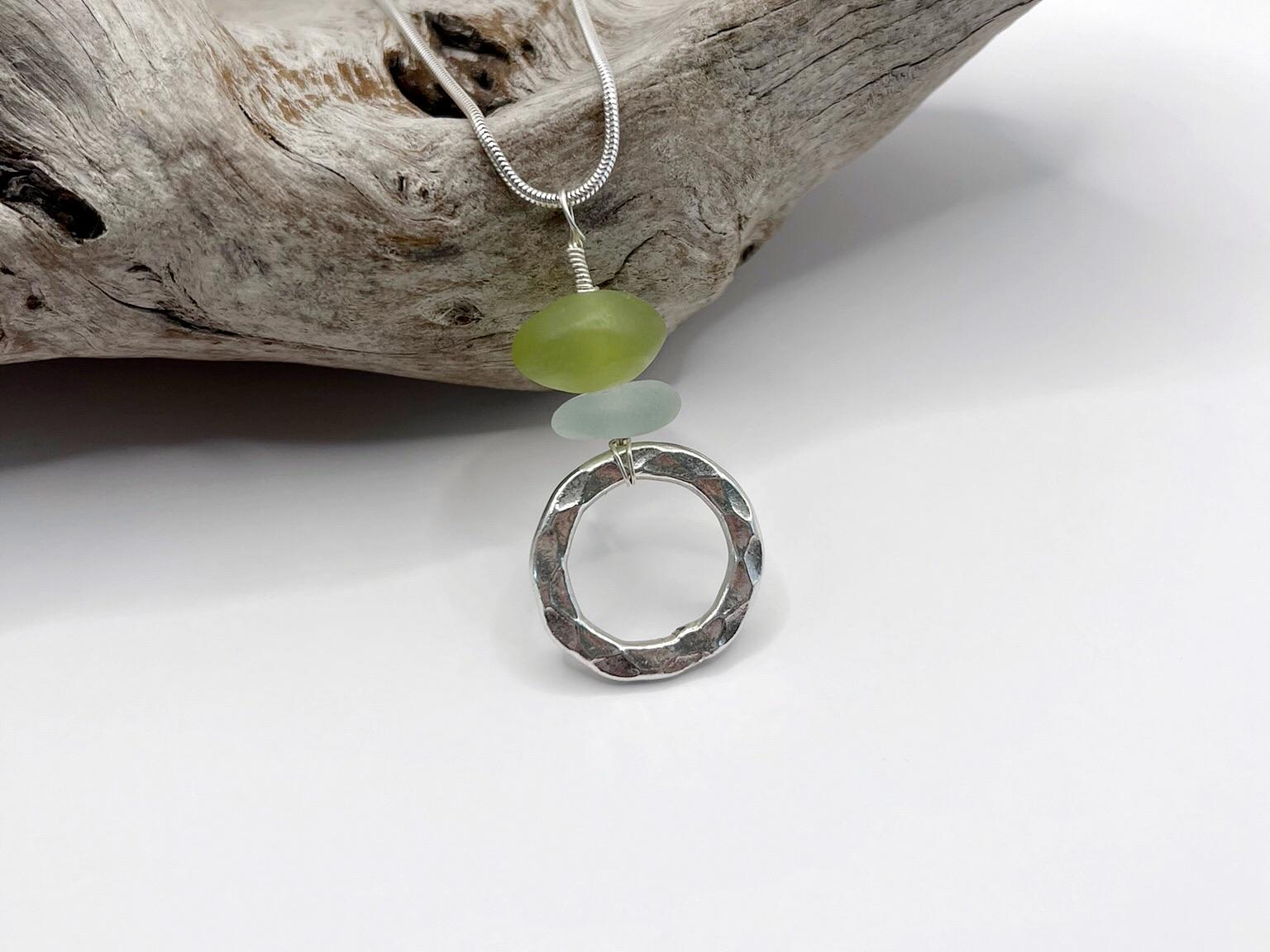 Necklace with a silver ring, green Jade and sea glass on a white background