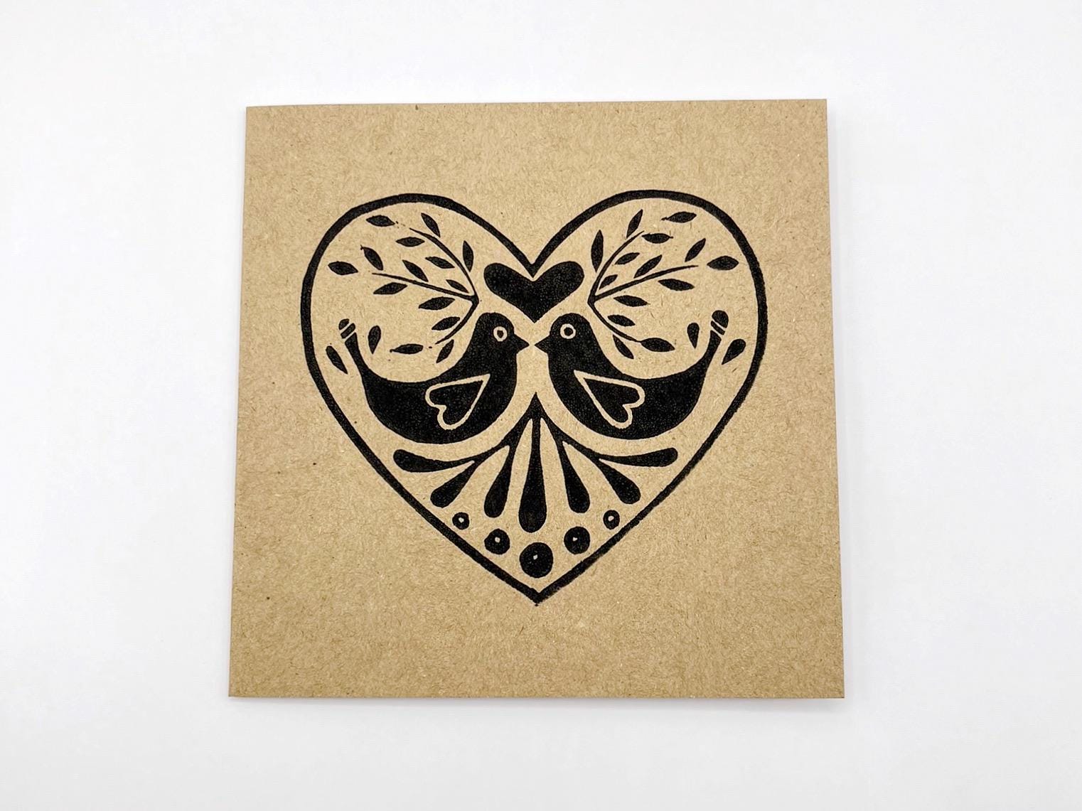 Kraft card with black heart design featuring two birds on a white background