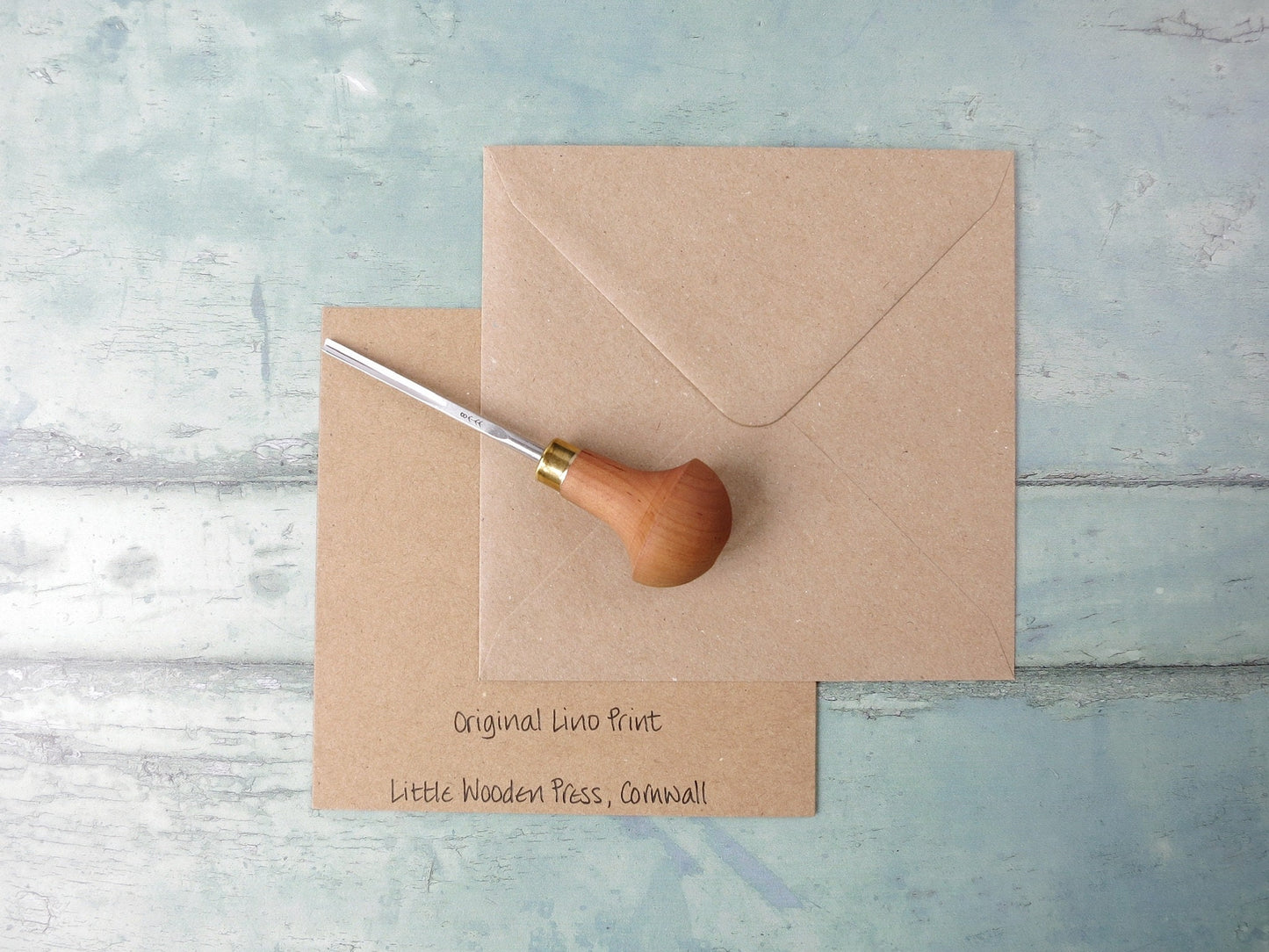 Showing the back of the card with text and matching envelope. Photo includes lino cutting tool 