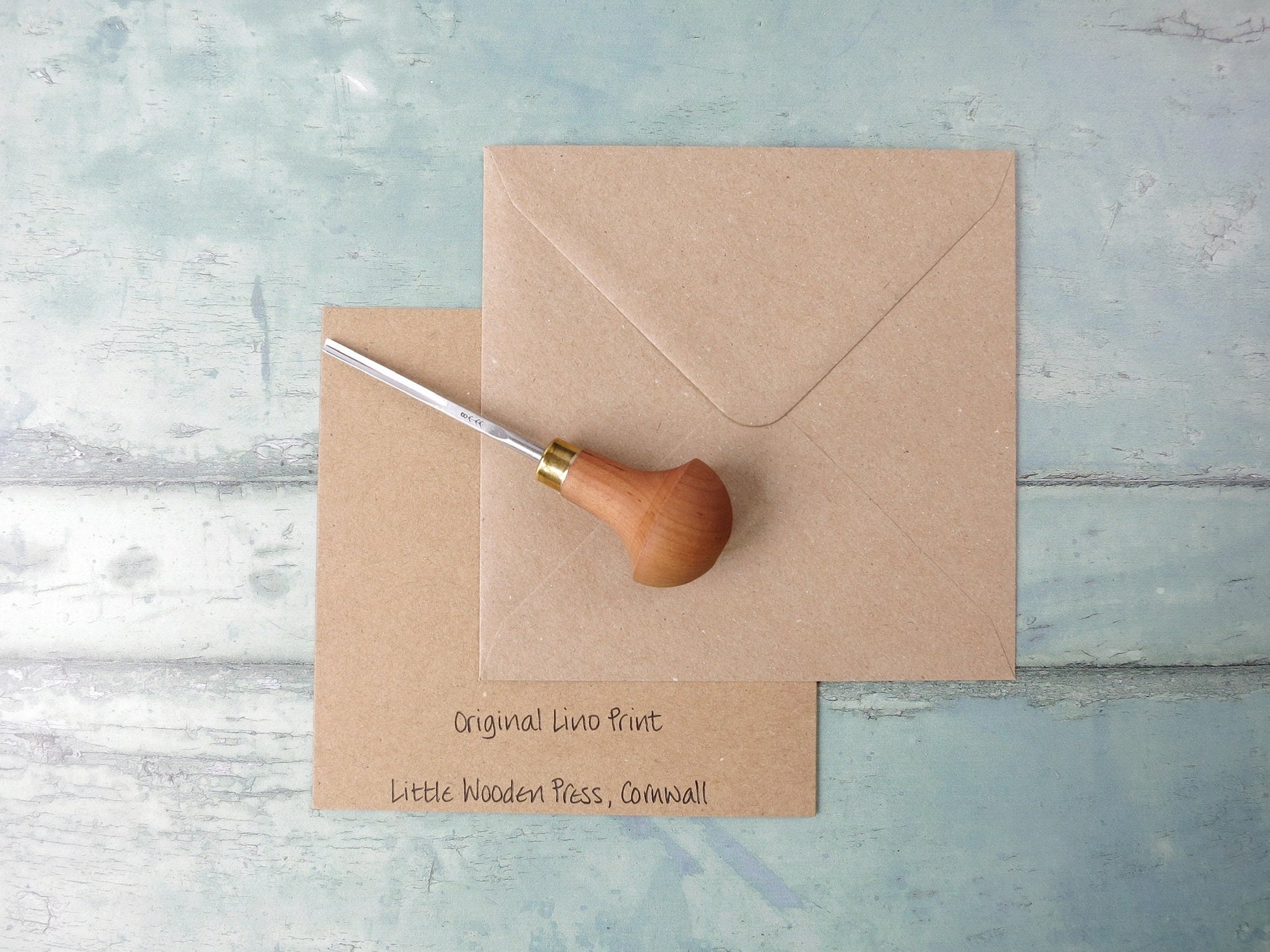 Showing the back of the card with text and matching envelope. Photo includes lino cutting tool 