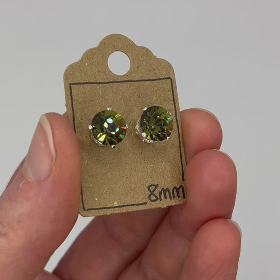 Video of cut glass stud earrings on a backing card, held in hand and moving to show the sparkle.